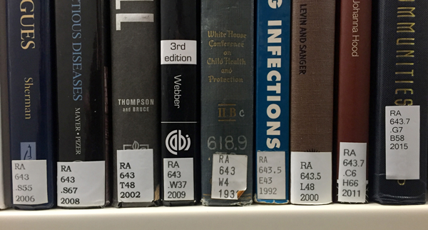 Photo of books on a shelf with call number labels