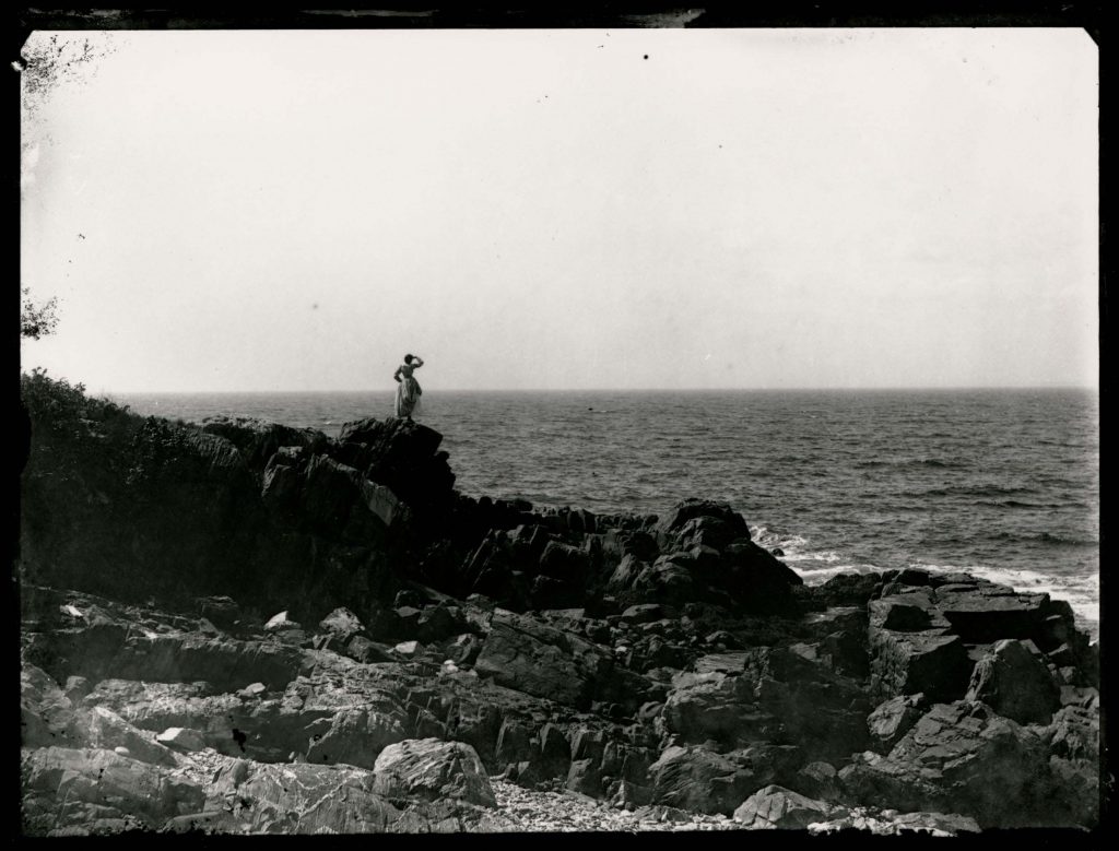 Woman Standing in Rocks Overlooking Water Aug. 1890