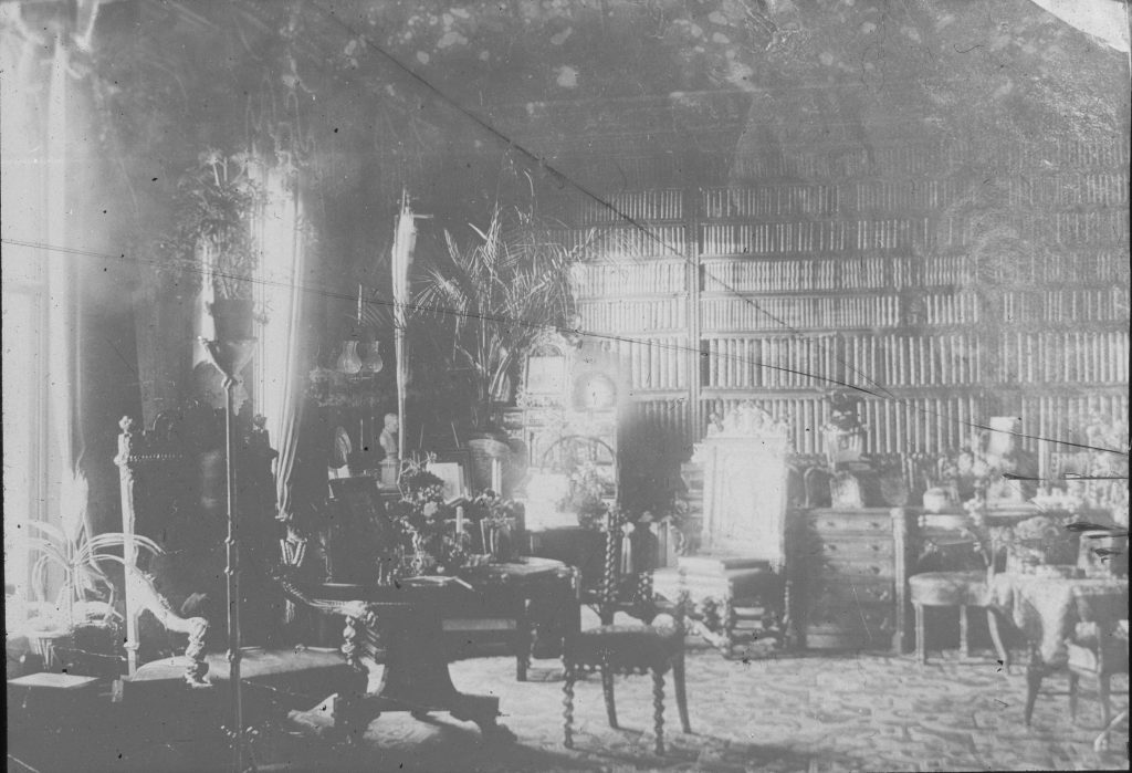 Cracked lantern slide photograph showing an ornate library room in black and white with a mysterious light in the center