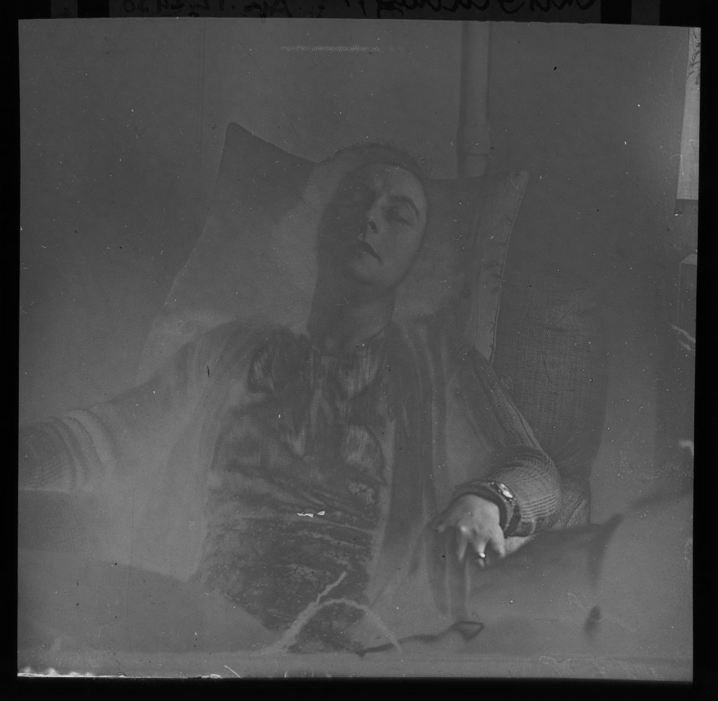 A negative photograph of a woman, Mrs. Fielding, sitting with her head resting back in trance. 