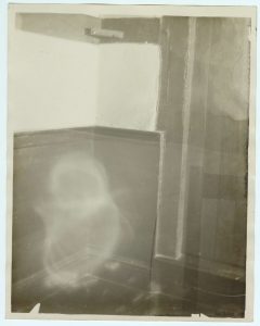 Photograph of an apparition at Ash Manor. Indistinguishable blobs of light appear in the bottom left and top right corner of the image.