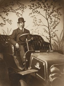 Man sitting in studio prop car.