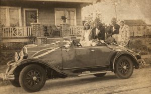 Two couples posing in car.