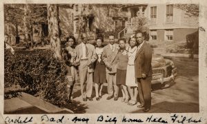 family picture in front of car.