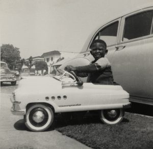 young boy in white toy car