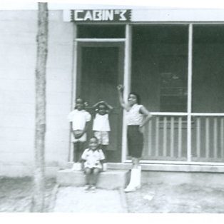 Three children and their mother pose in front of Cabin 3