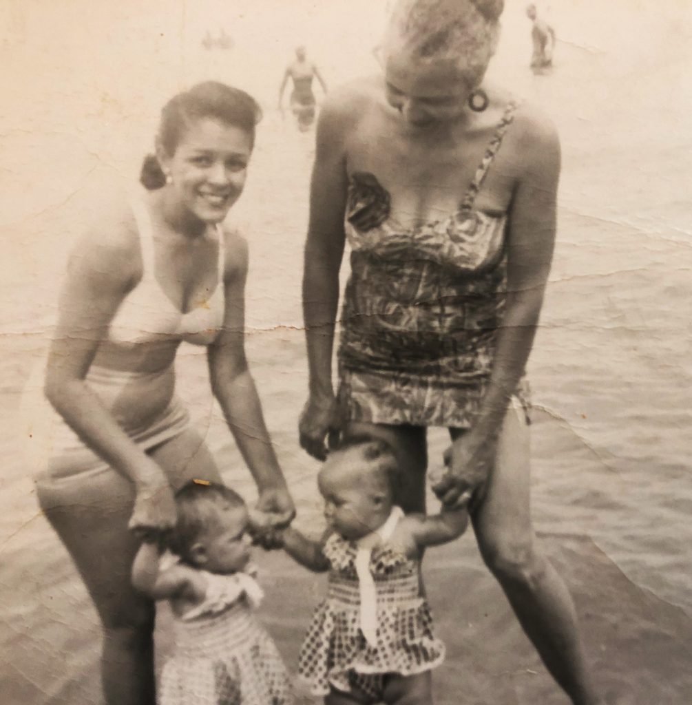 Black and white image of two women and two children in the water at Highland Beach.