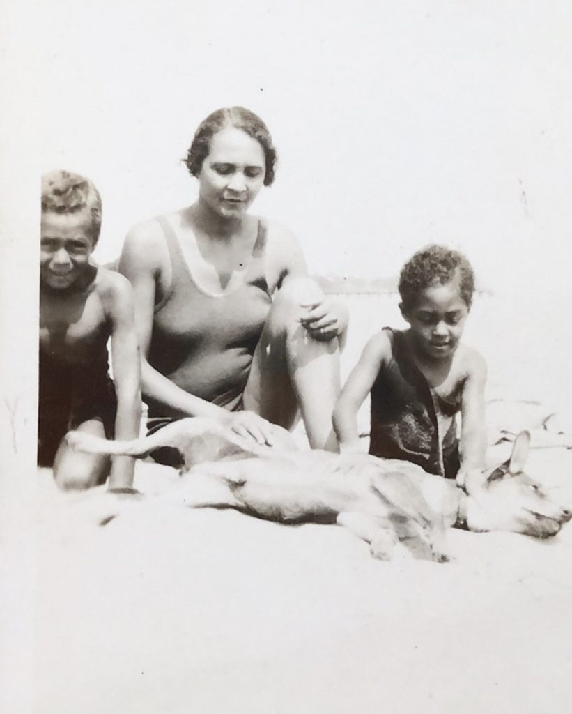 One woman, two children, and their family dog relaxing at Highland Beach