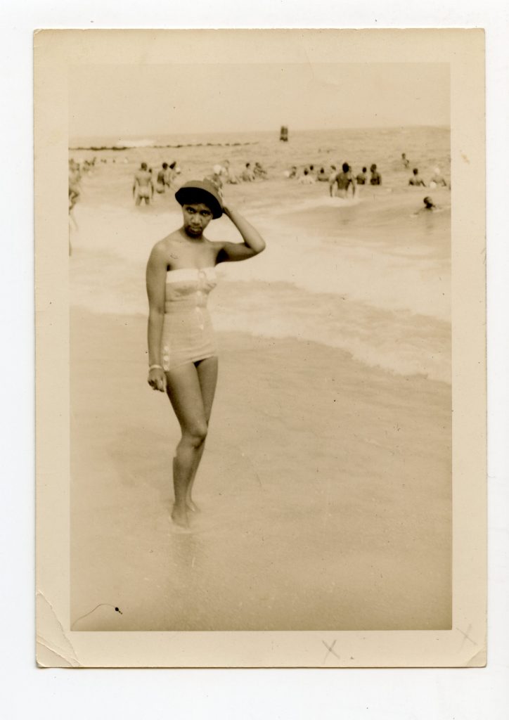 A woman posing on the beach.