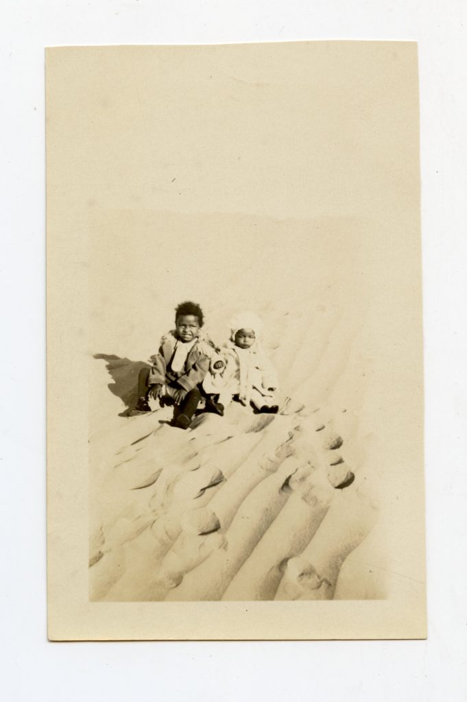 Two little kids in the sand.