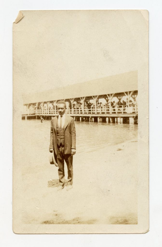 Man standing on shore wearing suit.