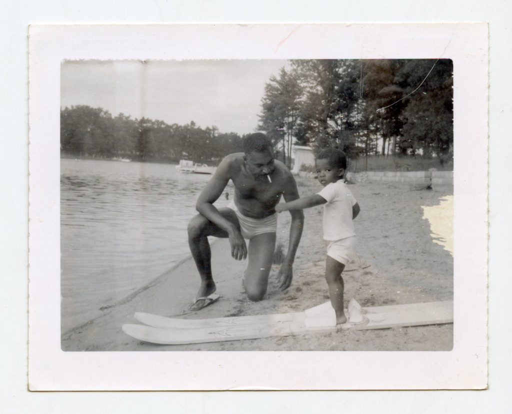 Man with a kid with water skies.