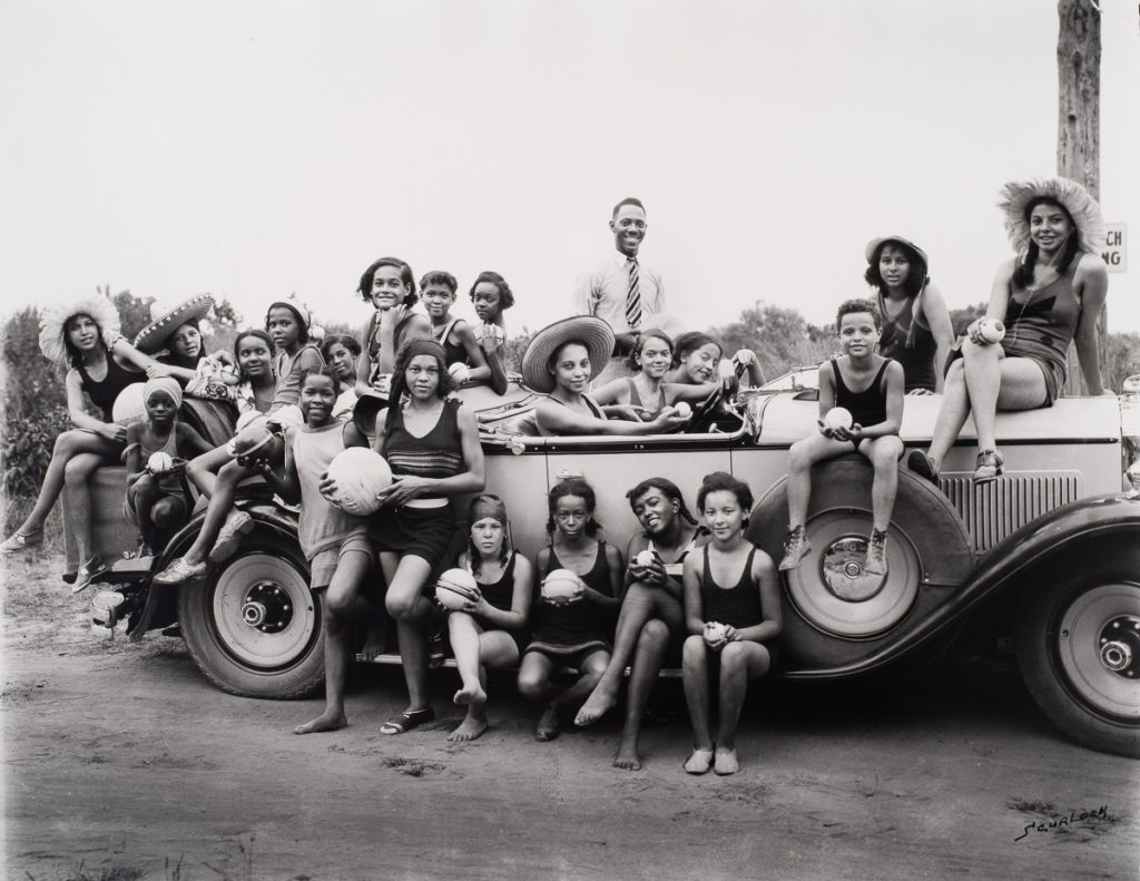 Group of people standing in front of a car at Highland Beach, MD