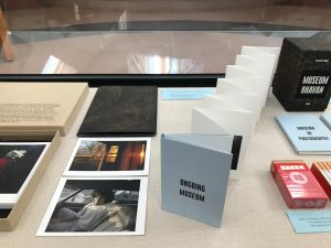 Materials from the Bafford Photography Book Collection displayed in Case 3. The case features various items such as photographs laying down, and books standing upright.