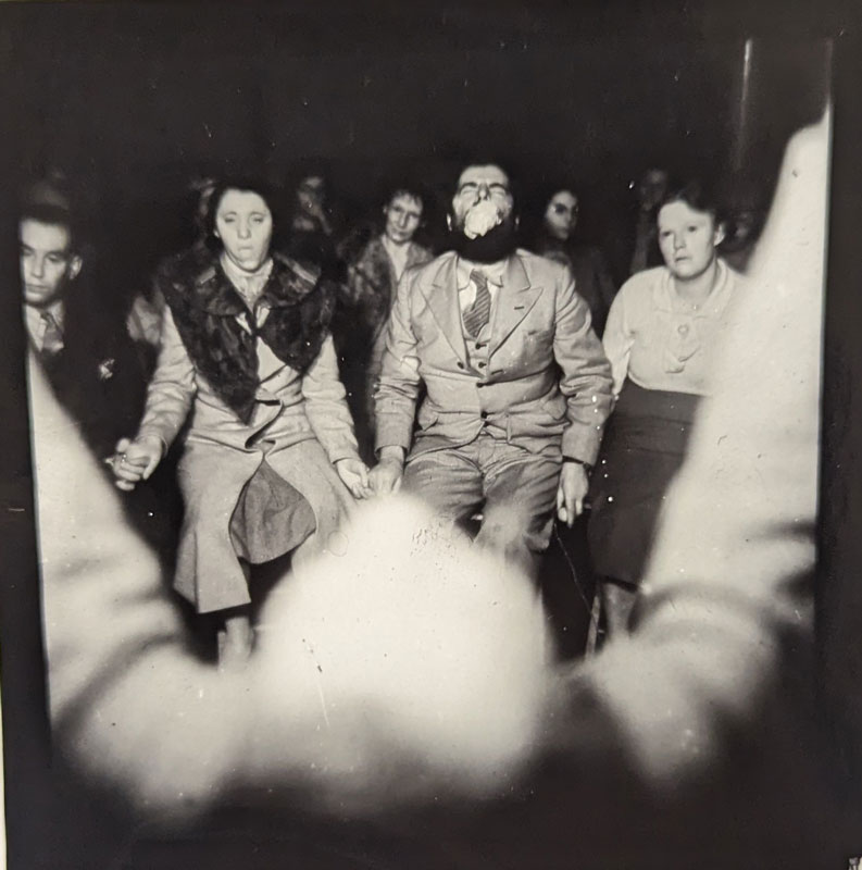 View of seance circle from behind a man's head. 