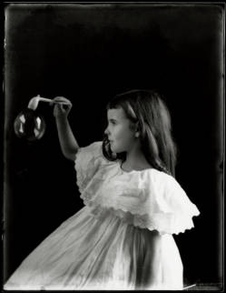 Black and white photograph of a girl with a bubble wand