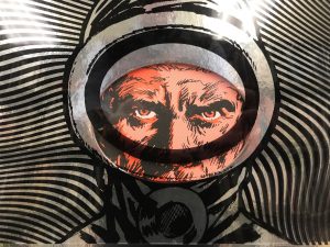 Cover art for science fiction comic The Eternaut, created by Héctor Germán Oesterheld with artwork by Francisco Solano López. The cover artwork features a man in an astronaut suit looking forward with a striped background.