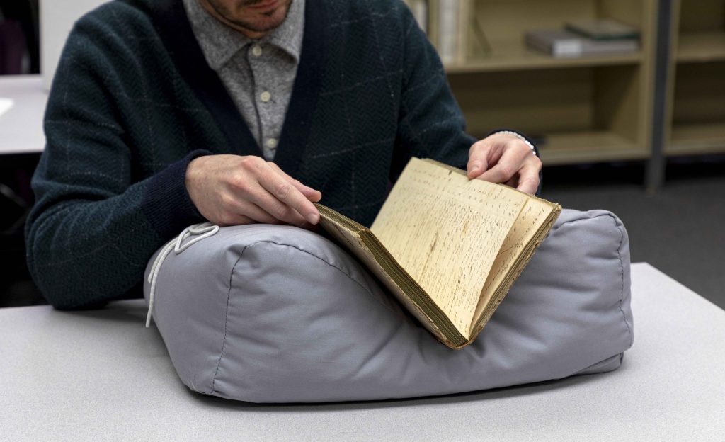 Research looking at a book in a book cradle