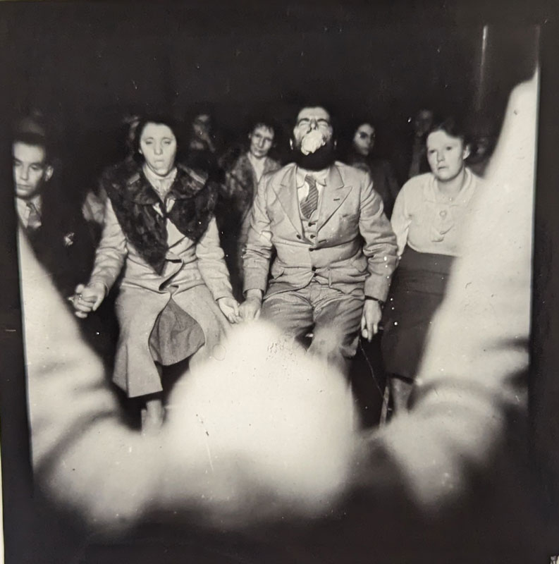 View of seance circle from behind a man's head.